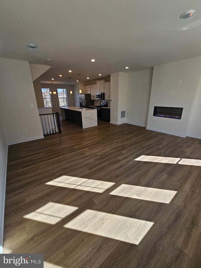 unfurnished living room featuring dark wood-type flooring