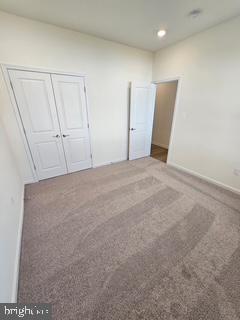 unfurnished bedroom featuring carpet and a closet