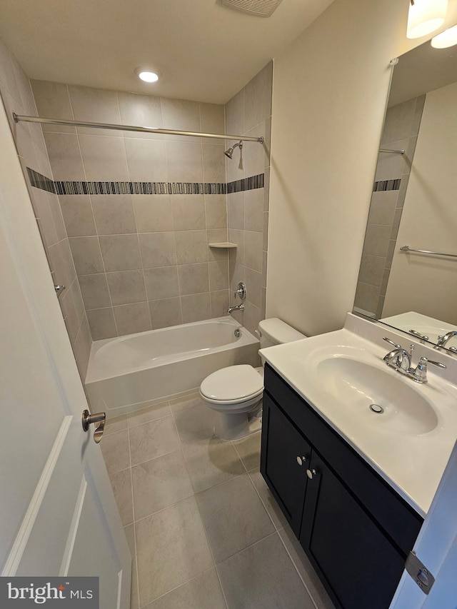 full bathroom featuring tiled shower / bath combo, vanity, tile patterned floors, and toilet