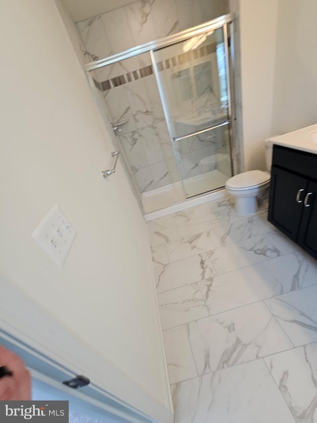 bathroom featuring vanity, toilet, and an enclosed shower