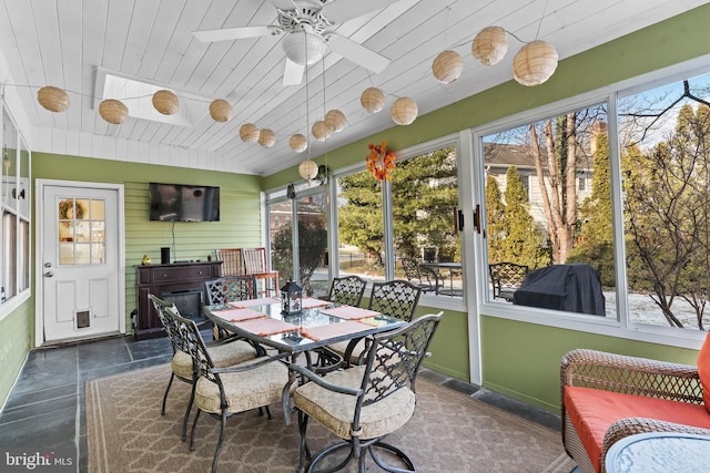 sunroom featuring lofted ceiling, ceiling fan, and wood ceiling