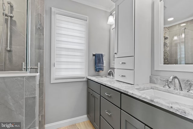 bathroom with vanity, an enclosed shower, and ornamental molding