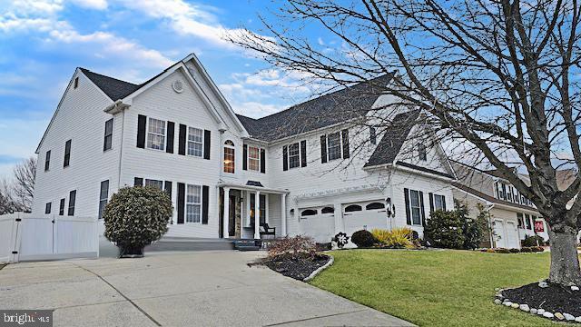 view of front of house featuring a garage, driveway, a front yard, and fence