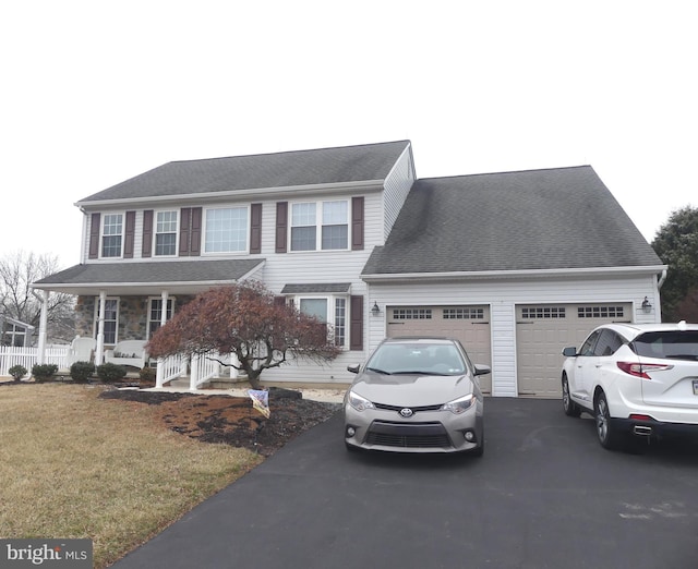 view of front of property with a garage, covered porch, and a front lawn