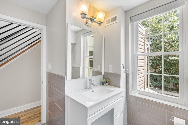 bathroom featuring tile walls, vanity, and hardwood / wood-style floors