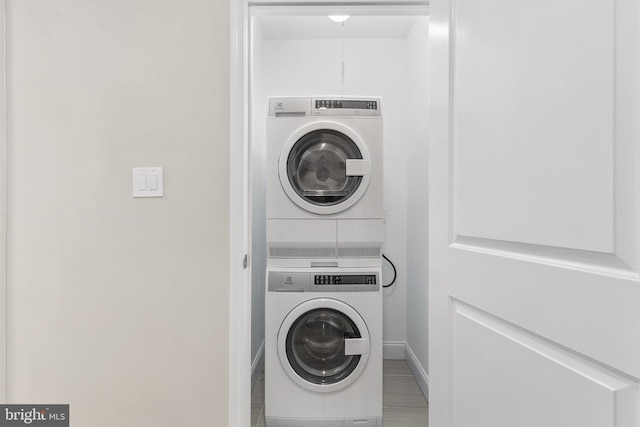 clothes washing area featuring stacked washer / drying machine