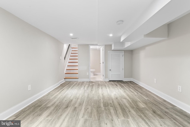 basement with light hardwood / wood-style flooring