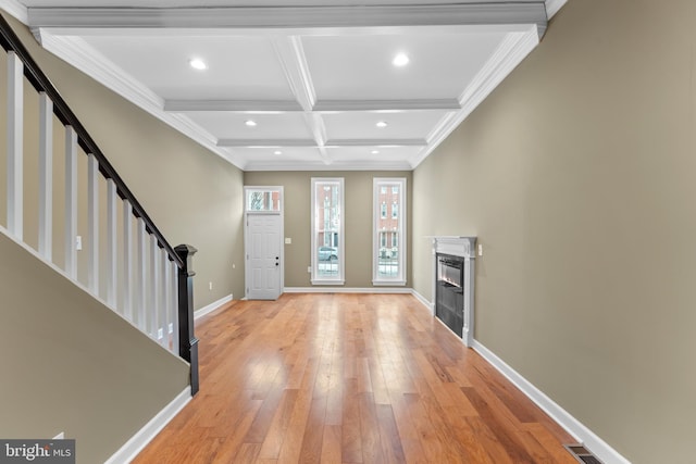 entryway featuring ornamental molding, coffered ceiling, beam ceiling, and light hardwood / wood-style flooring