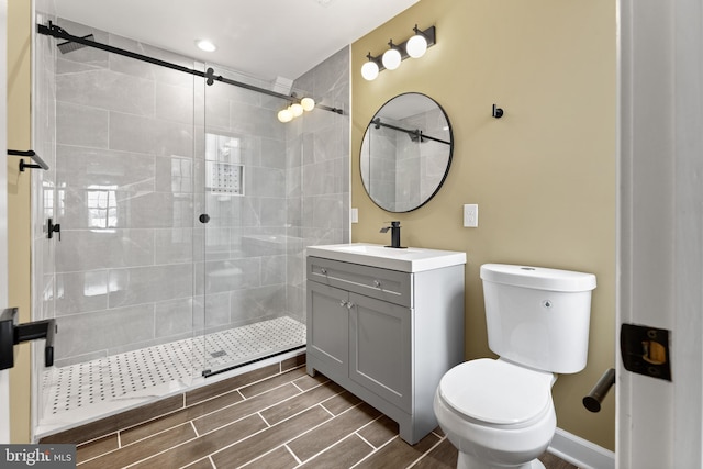 bathroom featuring vanity, toilet, and a shower with shower door