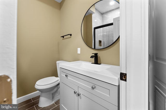 bathroom featuring vanity, toilet, and walk in shower