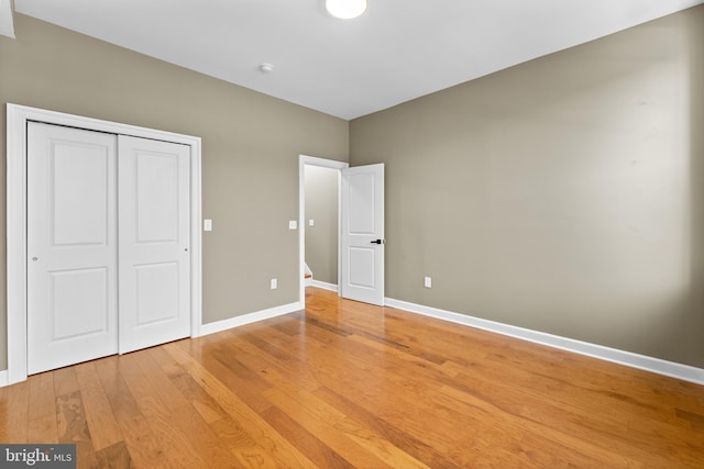 unfurnished bedroom featuring light hardwood / wood-style flooring and a closet