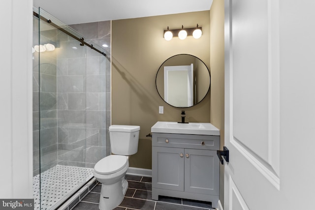 bathroom featuring vanity, a shower with door, and toilet