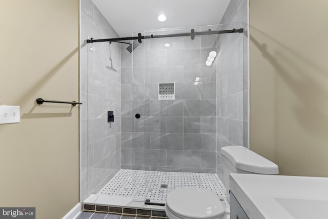 bathroom featuring a shower with door, vanity, and toilet