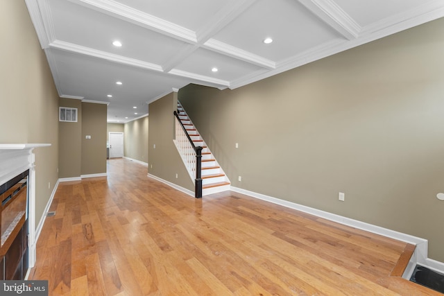 unfurnished living room with crown molding, coffered ceiling, light hardwood / wood-style floors, and beamed ceiling