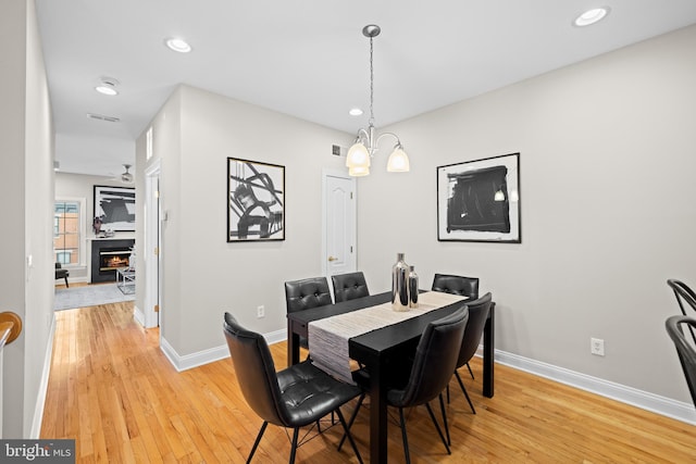 dining area with hardwood / wood-style flooring and a notable chandelier