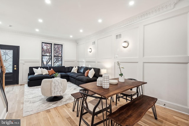 dining area featuring crown molding and light hardwood / wood-style floors