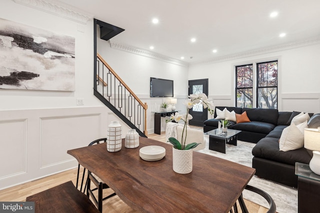 living room featuring crown molding and light hardwood / wood-style flooring