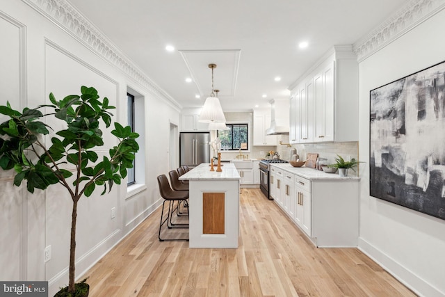 kitchen featuring white cabinetry, a kitchen bar, a kitchen island, and appliances with stainless steel finishes