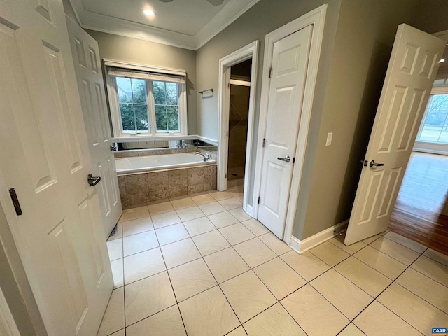 bathroom with tiled tub, ornamental molding, plenty of natural light, and tile patterned floors