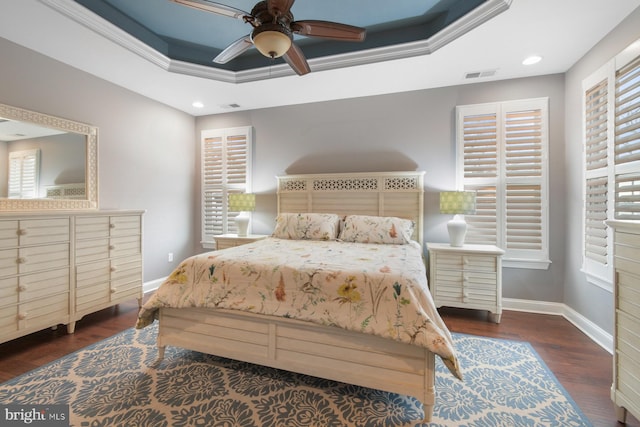 bedroom with dark hardwood / wood-style flooring, ornamental molding, a raised ceiling, and ceiling fan