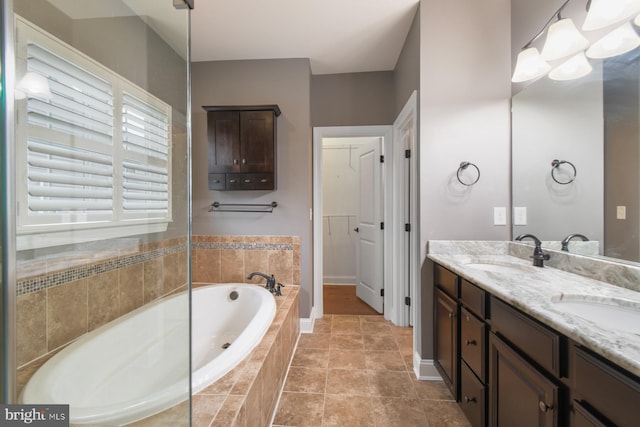 bathroom featuring vanity, tiled bath, and tile patterned floors