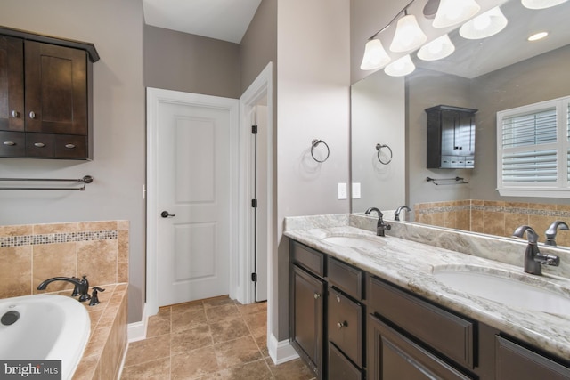 bathroom with vanity and tiled bath