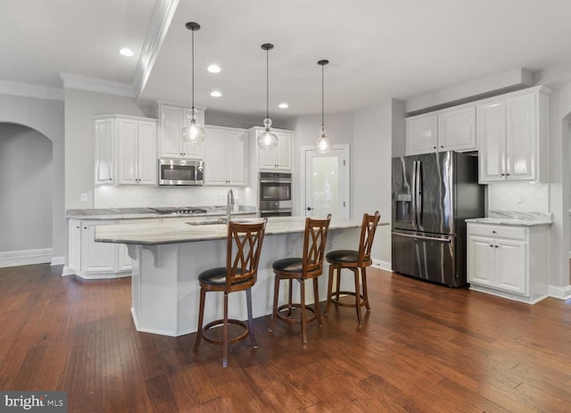 kitchen with sink, appliances with stainless steel finishes, a kitchen island with sink, hanging light fixtures, and white cabinets