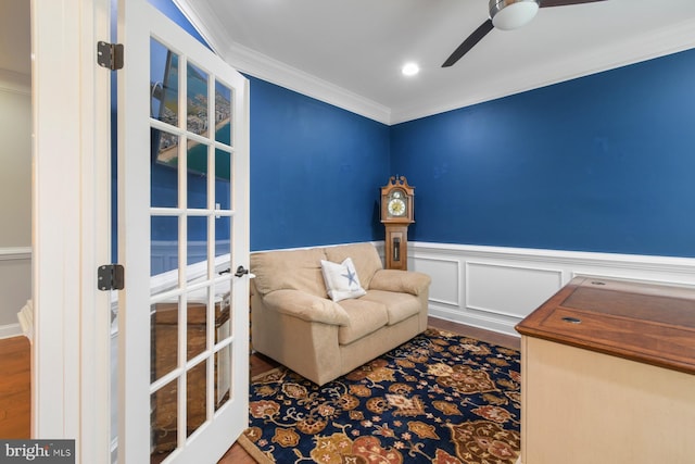 sitting room with wood-type flooring, ornamental molding, ceiling fan, and french doors