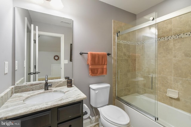 full bathroom with enclosed tub / shower combo, vanity, and toilet