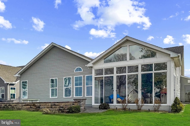 back of house with a yard and a sunroom