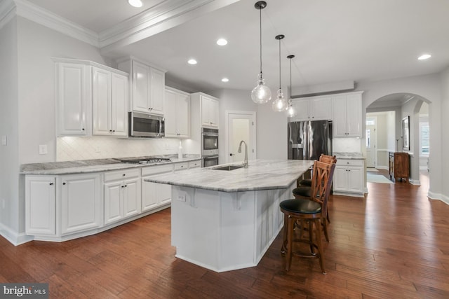 kitchen featuring stainless steel appliances, sink, an island with sink, and white cabinets