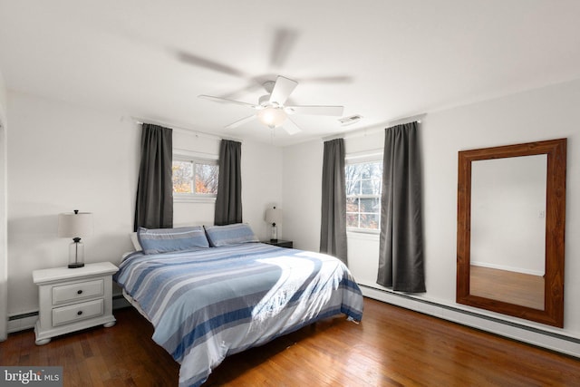 bedroom with dark hardwood / wood-style flooring, ceiling fan, and baseboard heating