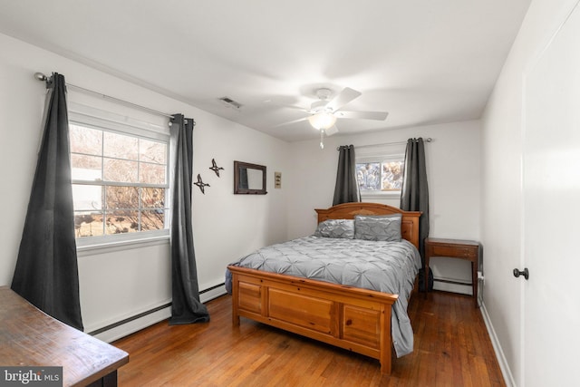 bedroom featuring baseboard heating and hardwood / wood-style floors