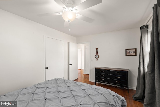 bedroom with dark hardwood / wood-style flooring and ceiling fan