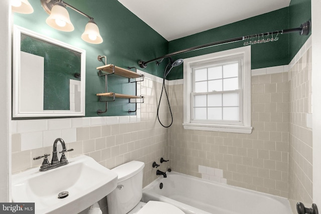 full bathroom featuring tile walls, sink, toilet, and tiled shower / bath