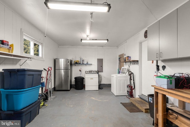 garage featuring stainless steel refrigerator, independent washer and dryer, and electric panel