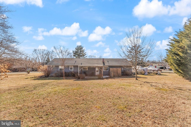 rear view of property with a yard