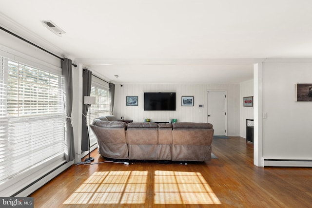 living room featuring hardwood / wood-style flooring, a baseboard radiator, and crown molding