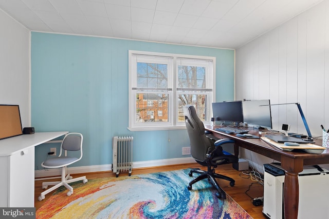 home office with hardwood / wood-style floors and radiator heating unit