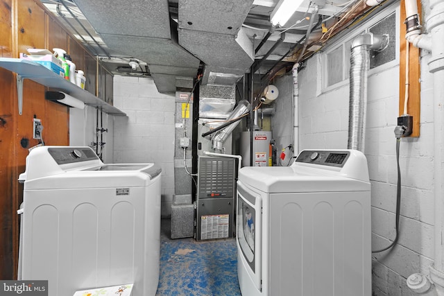 clothes washing area featuring heating unit, washer and clothes dryer, and water heater