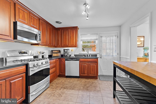 kitchen featuring appliances with stainless steel finishes, sink, and light tile patterned floors