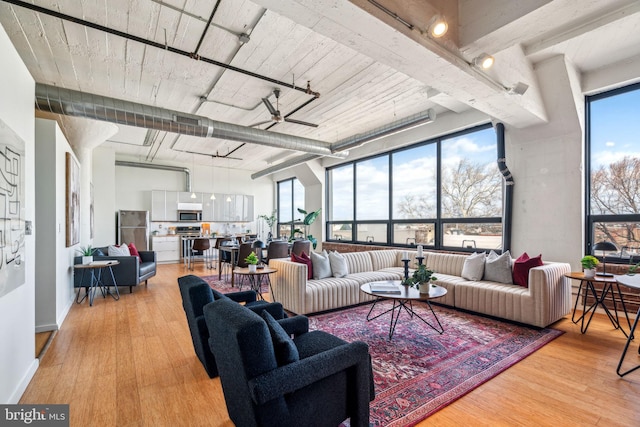 living room featuring a towering ceiling and light wood-type flooring