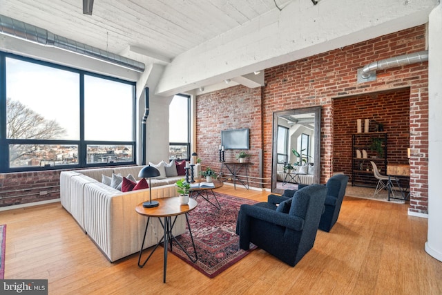 living room featuring brick wall and light hardwood / wood-style floors