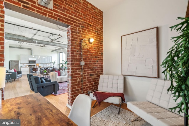 interior space featuring brick wall and light wood-type flooring