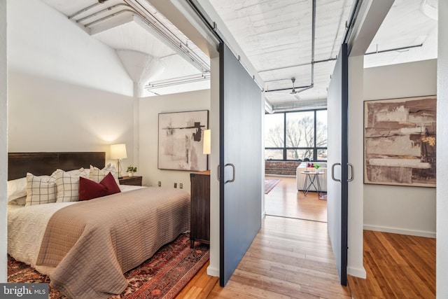 bedroom with expansive windows and light wood-type flooring