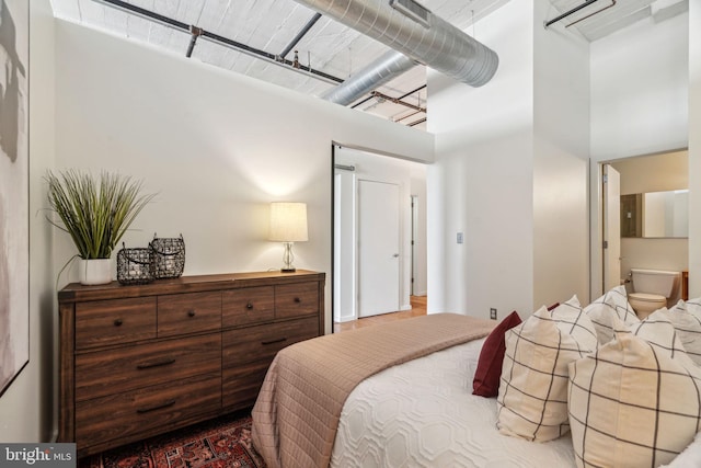 bedroom featuring a towering ceiling and connected bathroom