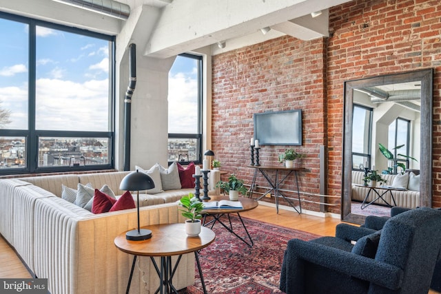 living room with hardwood / wood-style floors and brick wall