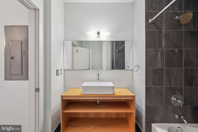 bathroom featuring vanity, electric panel, and tiled shower / bath