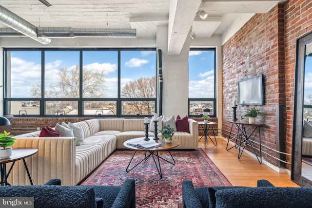 interior space with hardwood / wood-style flooring and brick wall