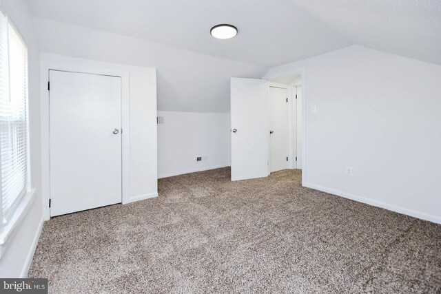 bonus room with baseboards, lofted ceiling, and carpet flooring
